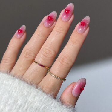 A pink ombre manicure with 3D heart nail art