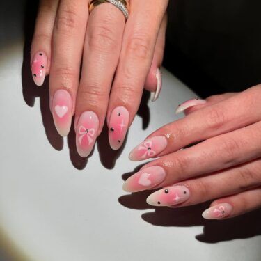 An ombre manicure with airbrush heart designs