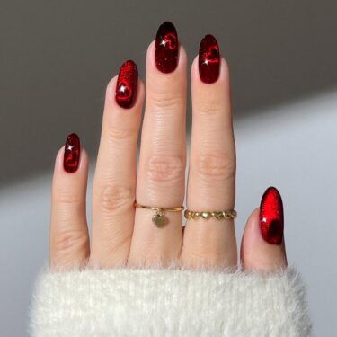 A shiny red manicure with heart designs